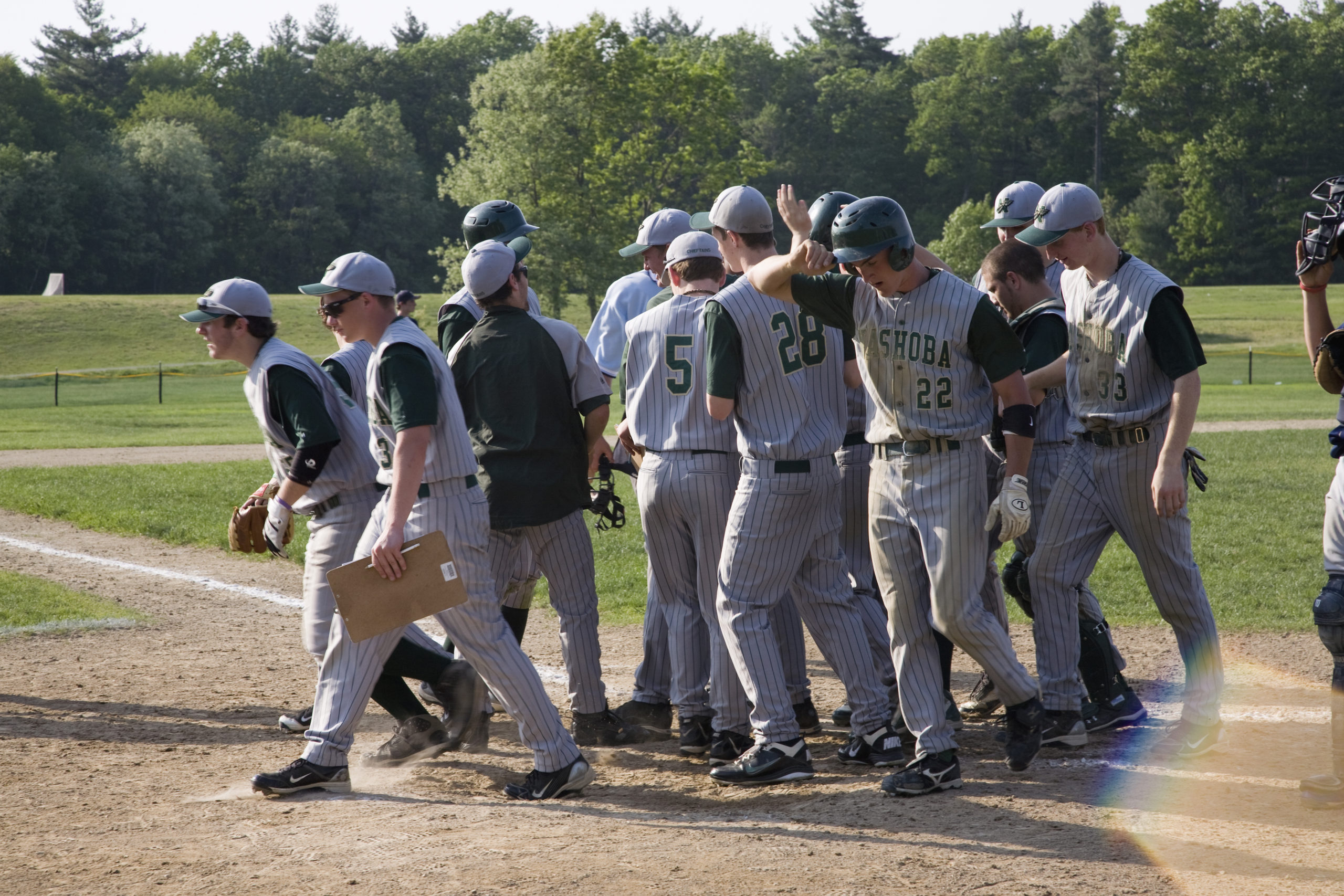 A travel ball team breaks from a huddle before starting a baseball game. 